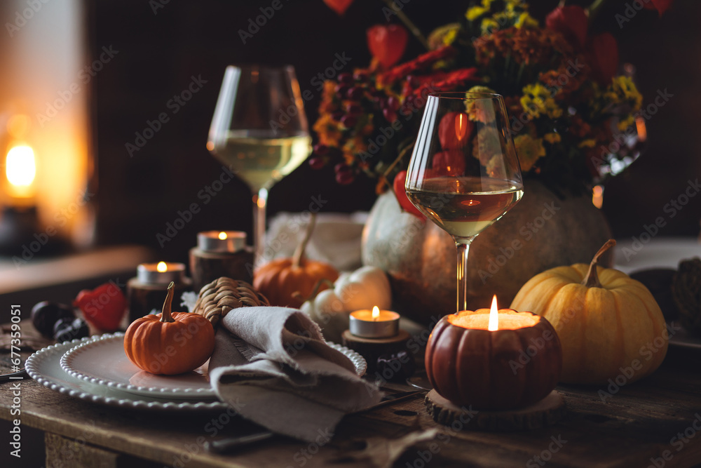 Atmospheric autumn elegant beautiful table setting with pumpkins for a wedding or thanksgiving family celebration. Fall decoration countryside rustic style, cozy home atmosphere , candles, wine
