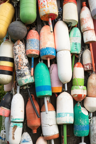 Various colored old Maine lobster trap buoys hanging. Colorful background. photo