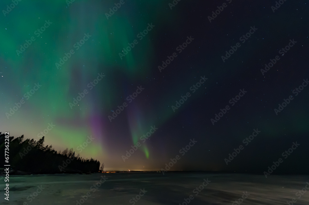 Green and purple aurora borealis over the frozen lake Näsijärvi in Tampere, Finland Green and purple aurora borealis over the frozen lake Näsijärvi in Tampere, Finland