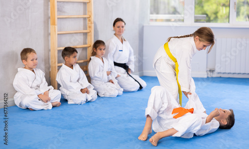 Young karate students engage in sparring match, demonstrating their martial art skills.