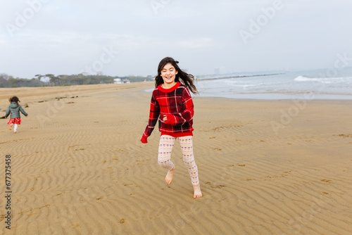 smiling girl with long hair running on the sandy beach
