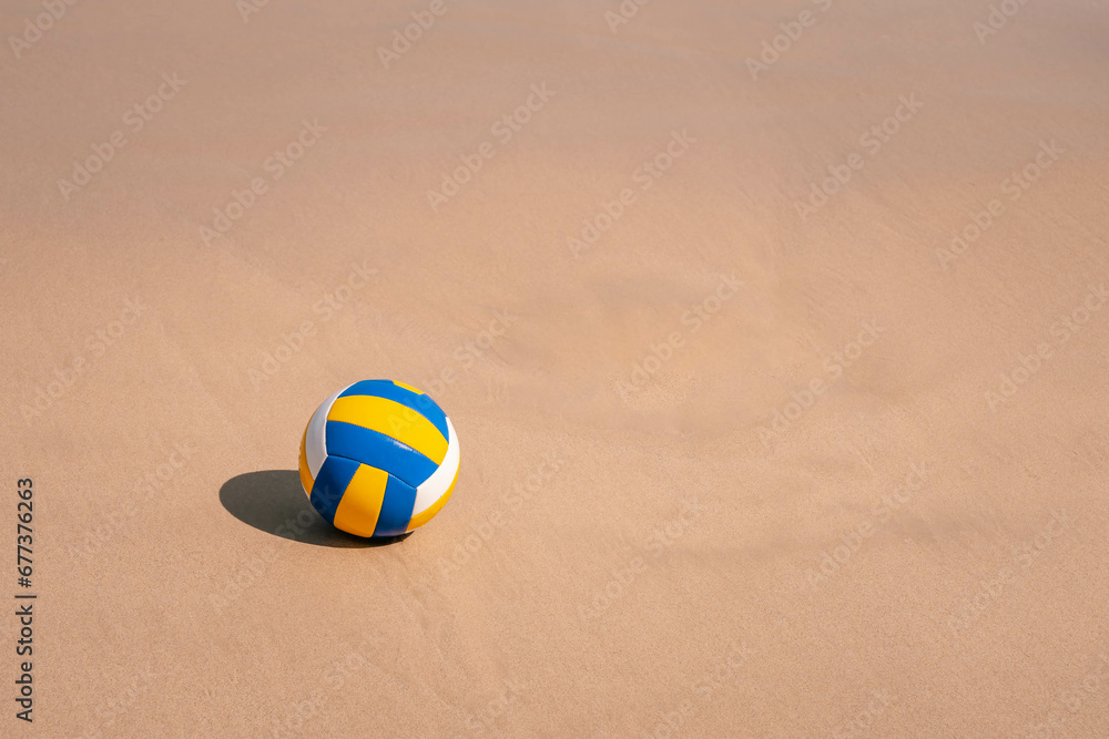 Ball at wet sandy beach. Blue yellow white stripes. Close up photo