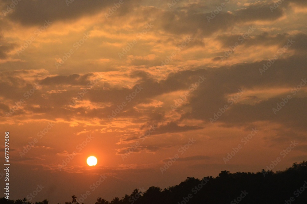Beautiful shot of the sunset behind the clouds in the evening Beautiful shot of the sunset behind the clouds in the evening