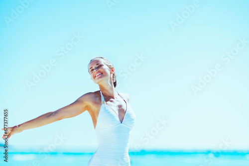 young woman walking rejoicing on sea sho
