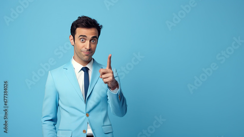Portrait of confident salesman pointing at product with copy space while standing on blue background

