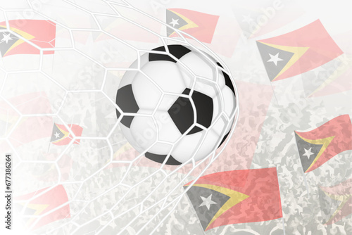 National Football team of East Timor scored goal. Ball in goal net, while football supporters are waving the East Timor flag in the background.