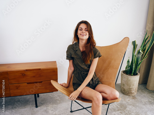 Woman model sits on a chair at home smile, fun and relaxation, modern stylish interior scandia lifestyle, copy space. photo