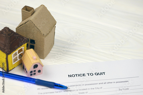 Notice to quit or eviction notice blank document paper ready to fill with small toy houses on table close up photo