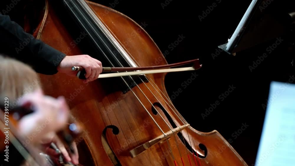 Violin and double bass close-up on a black background. Male and female hands in kadri. Static frame. Violin and double bass close-up on a black background. Male and female hands in kadri. Static frame.