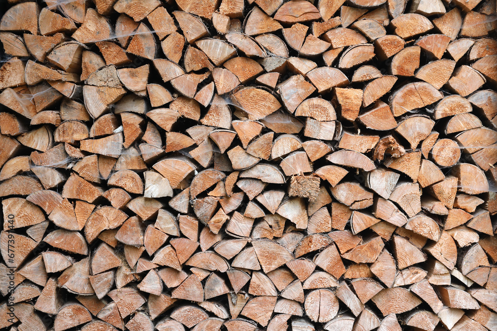Firewood stacked near the wooden wall of old hut. Many chopped logs of firewood close up Firewood stacked near the wooden wall of old hut. Many chopped logs of firewood close up