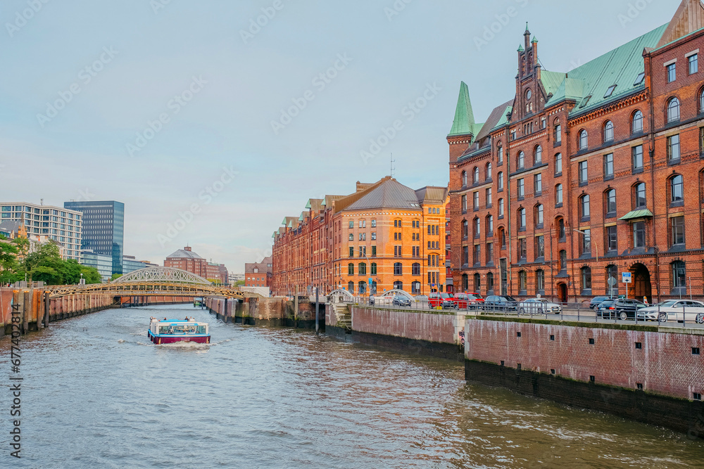 Hamburg, Germany - 25 October 2023: View on the brick  buildings and a touristic boat on a canal in Kehrwieder in Hamburg.