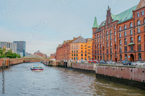 Hamburg, Germany - 25 October 2023: View on the brick buildings and a touristic boat on a canal in Kehrwieder in Hamburg.