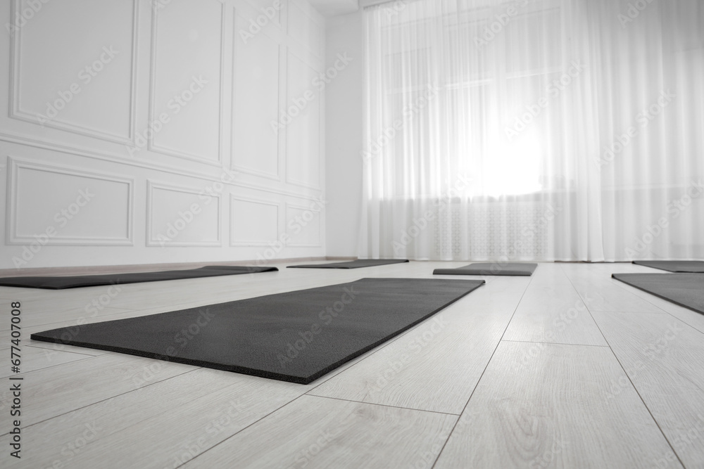 Spacious yoga studio with exercise mats. Space for text Spacious yoga studio with exercise mats. Space for text