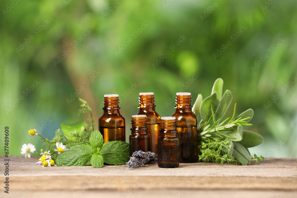 Bottles with essential oils and plants on wooden table against blurred green background. Space for text Bottles with essential oils and plants on wooden table against blurred green background. Space for text