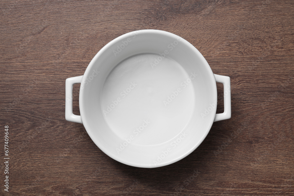 One white empty pot on wooden table, top view One white empty pot on wooden table, top view