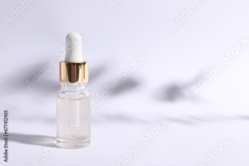 Bottle of cosmetic serum on white background. Space for text