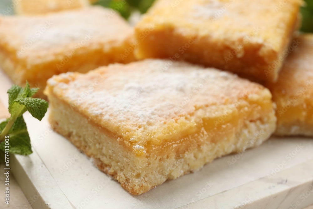 Tasty lemon bars with powdered sugar on table, closeup Tasty lemon bars with powdered sugar on table, closeup