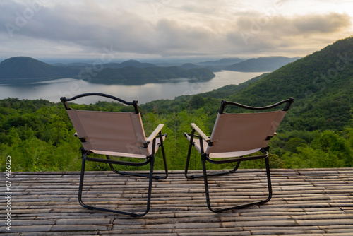 Two Empty Camping Chairs Standing on the Top of the Mount. Perfect Place for Watching Sunset. Actice Relaxation Lifestyle, Tourist tent in camp among with mountain view on sunrise, Travel vacation.