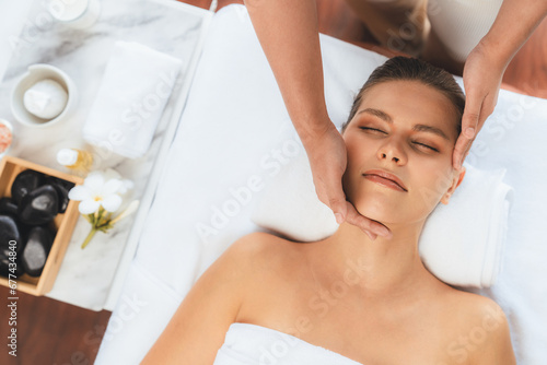 Panorama top view of woman enjoying relaxing anti-stress head massage and pampering facial beauty skin recreation leisure in dayspa modern light ambient at luxury resort or hotel spa salon. Quiescent photo