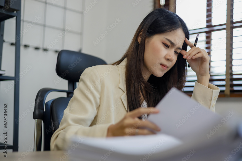 Curious young business woman working with documents in a workplace.. Curious young business woman working with documents in a workplace..