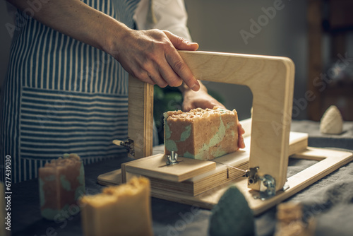 Cutting of homemade natural soap on a professional wood cutter. A means of eco-friendly hygiene and pleasant gifts