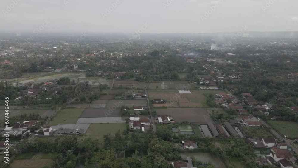 Drones over residential houses and urban rice fields in the countryside . Aerial view of a village and several houses burning rubbish Drones over residential houses and urban rice fields in the countryside . Aerial view of a village and several houses burning rubbish
