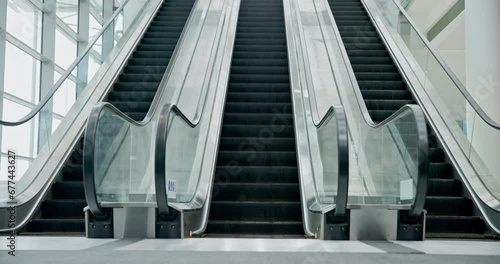 Escalator moving, machine and empty airport for travel in interior of building. Electronic, stairs and movement in office, mall or hotel technology for transportation on steps, stairway or staircase photo