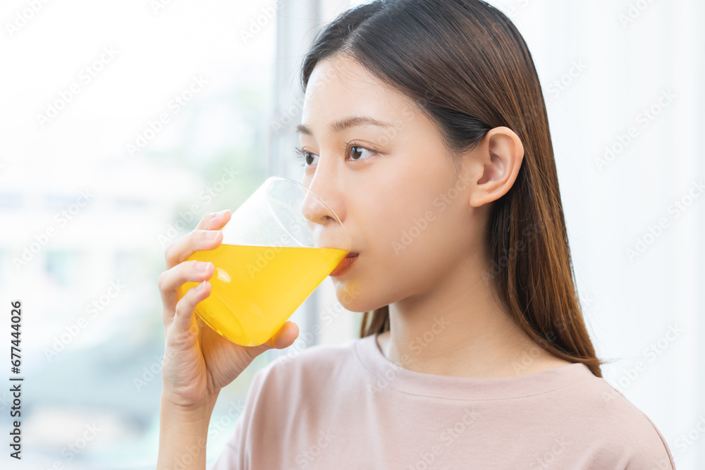 Asian young woman drinking, hand holding a glass of water after putting or dropping yellow effervescent tablet, painkiller medicine, aspirin for treatment, take vitamin c for hangover, health care. Asian young woman drinking, hand holding a glass of water after putting or dropping yellow effervescent tablet, painkiller medicine, aspirin for treatment, take vitamin c for hangover, health care.