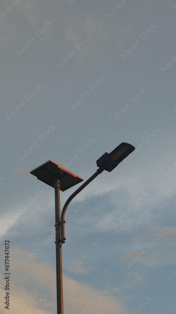 Lamppost on the background of the blue sky with clouds