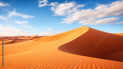 a sand dune with blue sky and clouds