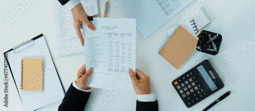 Corporate accountant team use calculator to calculate and maximize tax refunds and improve financial performance based on financial data report. Modern business accounting in panorama top view. Shrewd