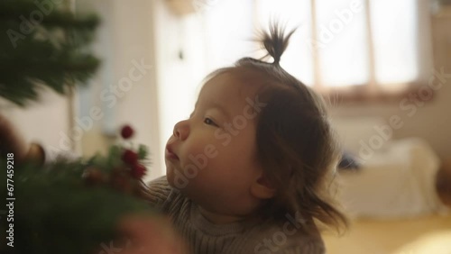 A baby in a sunny room playing on an spade