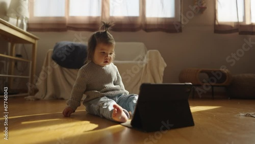 A baby in a sunny room playing on an spade