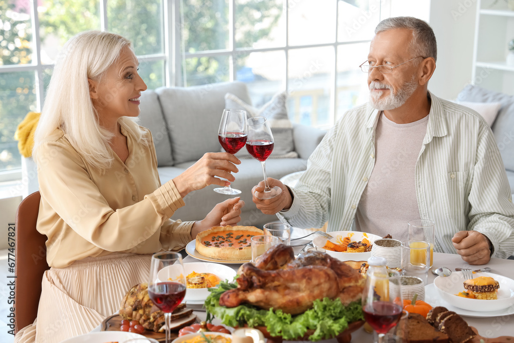 Mature couple having dinner at festive table on Thanksgiving Day Mature couple having dinner at festive table on Thanksgiving Day
