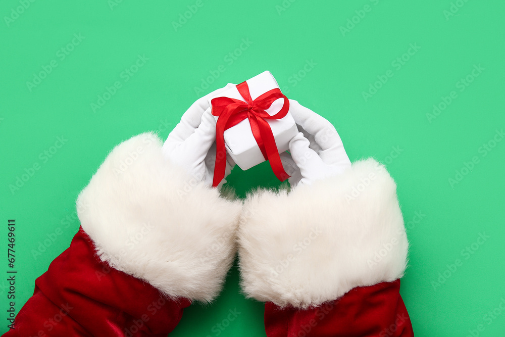 Santa Claus with white gift box on green background Santa Claus with white gift box on green background
