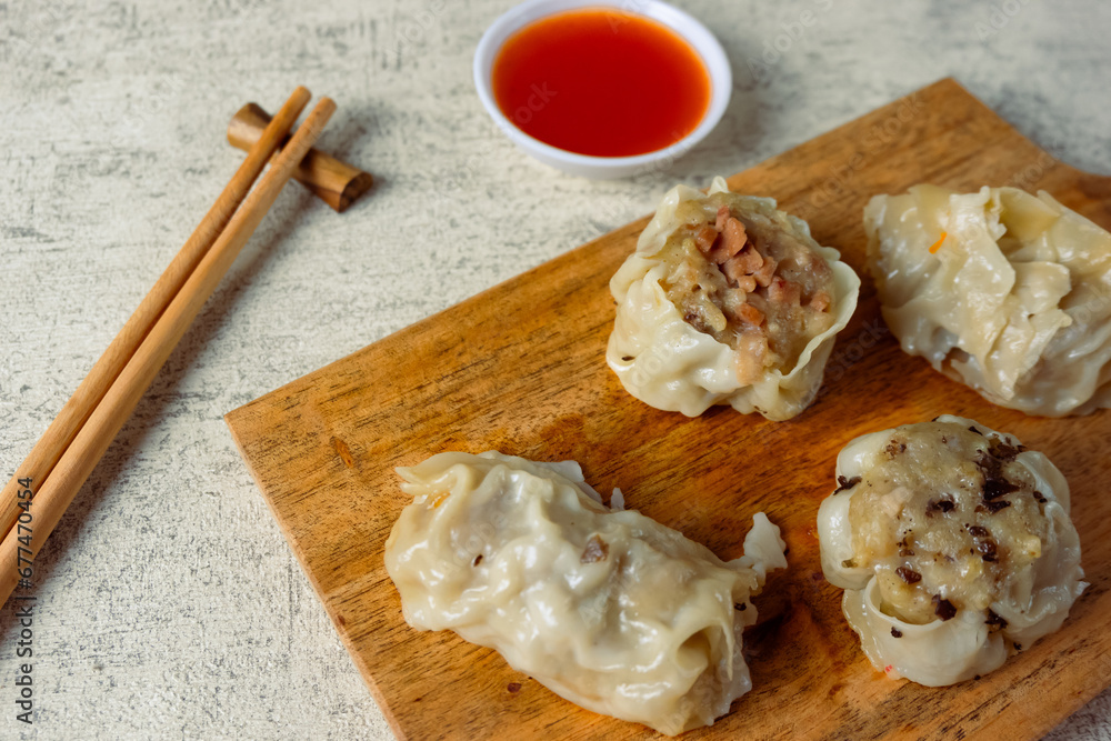 Dim sum with various fillings, from chicken, carrots, mushrooms and shrimp served with sauce. Dim sum with various fillings, from chicken, carrots, mushrooms and shrimp served with sauce.