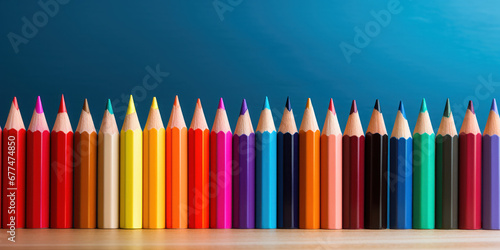 Row of multicolored pencils lies in order, a spectrum of potential on the table
