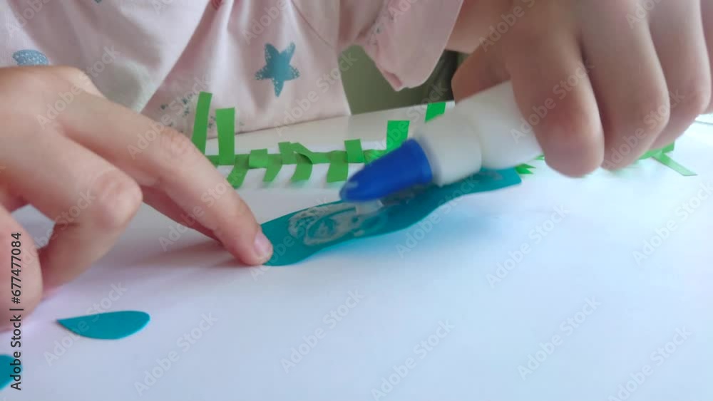 Cute child creating an applique with colored paper and glue. Concept of hobby Cute child creating an applique with colored paper and glue. Concept of hobby
