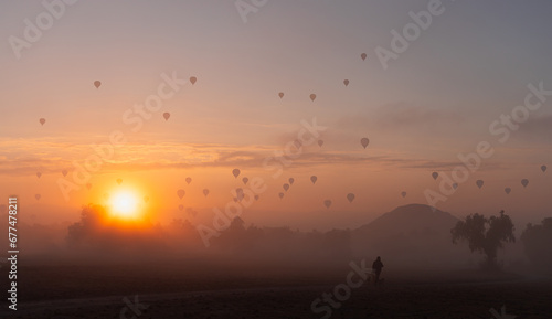 Hot air balloons flying over ancient pyramid of Teotihuacan at amazing sunset, Mexico
