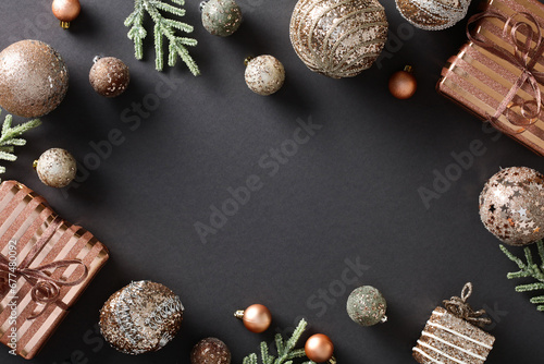 Chic and elegant Christmas composition with festive ornaments, confetti, and gift boxes on dark background. Luxury holiday design with copy space. Flat lay, top view.