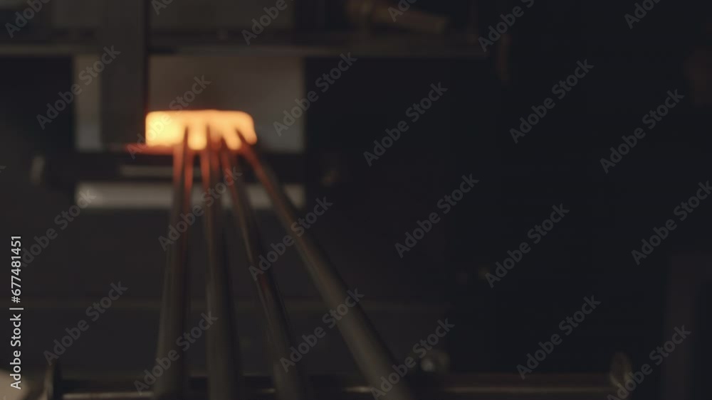 Zoom out no people shot of four blowpipes heating in hot furnace at glassblowing factory or workshop Zoom out no people shot of four blowpipes heating in hot furnace at glassblowing factory or workshop