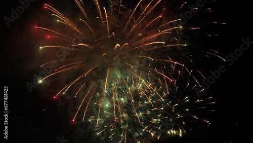 Fireworks sparkling flowers blasts with smoke cloud in black night sky