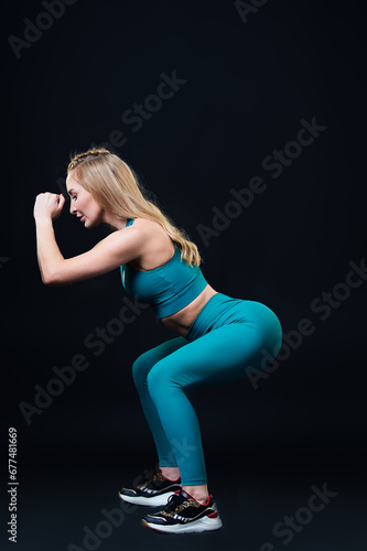 A young athlete performs stretching on a black background.