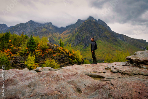 Hiker looking at a cloudy autumnal landscape in Thethi National Park, Albania. 