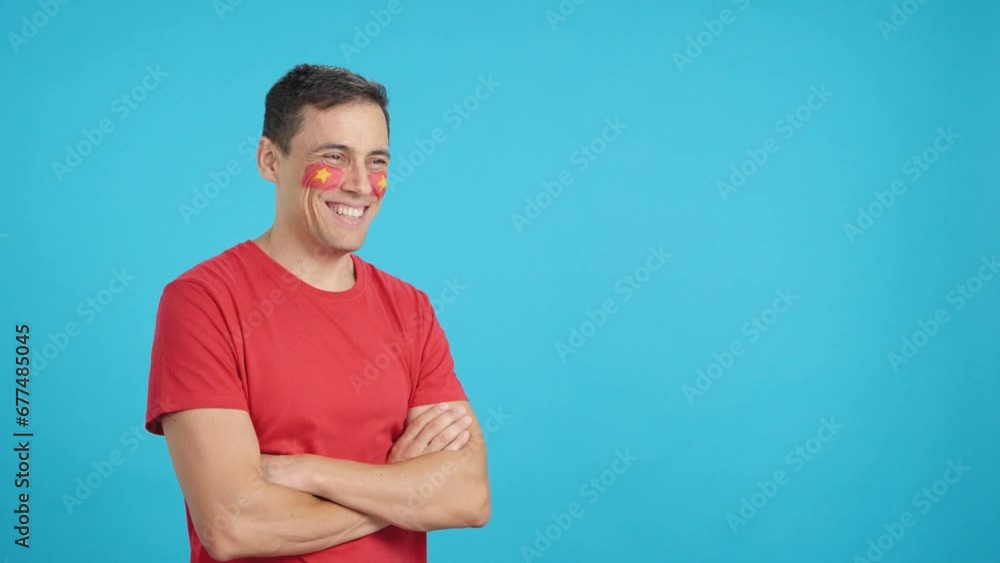 Happy man with vietnamese flag painted on face looking away Happy man with vietnamese flag painted on face looking away