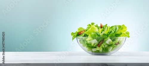 Salad vegetables in glass bowl on table on light background side view, healthy lifestyle concept, empty space horizontal panoramic banner photo
