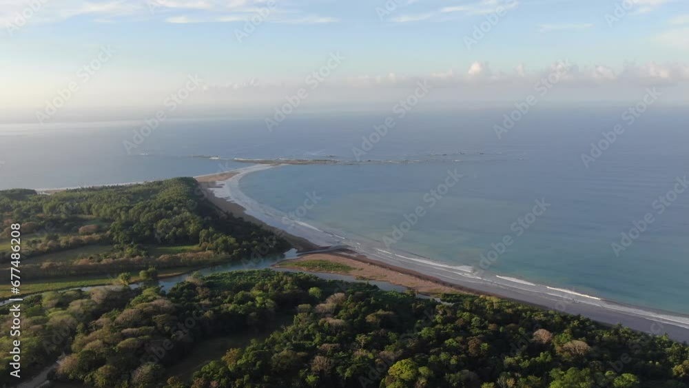 Costa Rica drone top view showing sea, shore and palm tree forest in the pacific ocean with a whale tale shape beach Costa Rica drone top view showing sea, shore and palm tree forest in the pacific ocean with a whale tale shape beach