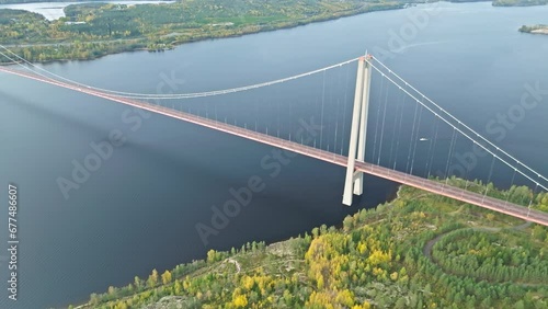 Above View Of The Stunning Infrastructure Of Hogakustenbron Bridge With Autumnal Coastal Forests In Sweden. Aerial Drone Shot photo