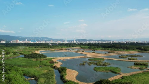 Drone dolly above wetland ponds at Guandu nature park with Taipei skyline in distance photo