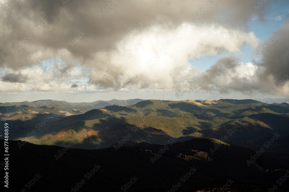Golden autumn in the Carpathians. Mining arrays combined with trees with yellow leaves. Beautiful clouds and sun